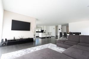 a living room with a couch and a tv on a wall at Basto Village House - Eco Smart Luxury Villa in Cabeceiras de Basto