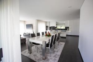 a kitchen and dining room with a white table and chairs at Basto Village House - Eco Smart Luxury Villa in Cabeceiras de Basto