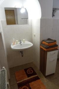 un bagno bianco con lavandino e specchio di Müllers erste Ferienwohnung in der Altstadt von Görlitz a Görlitz