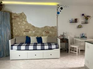 un letto bianco con cuscini blu in una stanza di Monolocale centro storico a Enna
