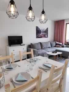 un salon avec une table et un canapé dans l'établissement Ferienwohnung AlpenGlück im Ferienpark Oberallgäu mit Hallenbad, Sauna, WLAN, à Missen-Wilhams