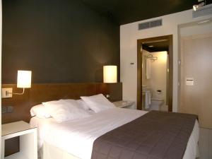 Кровать или кровати в номере Hostal Badaloní