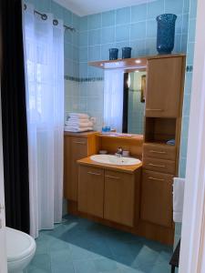 een badkamer met een wastafel en een spiegel bij CHAMBRE D'HOTES "Les Volets Bleus" - VILLA L'OLIVIER côté mer in Vaux-sur-Mer
