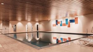 a swimming pool in a building with colorful art on the wall at Ferienwohnung Alpenglück im Allgäu in Missen-Wilhams