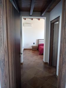 um corredor com um quarto com uma cama e uma porta em CASA RURALE IMPASTATO em Montevago