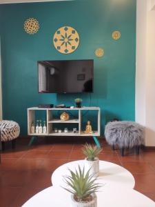 a living room with a tv on a blue wall at DEPARTAMENTO a 5 cuadras de la Av Aristides - Ubicacion super privilegiada in Mendoza
