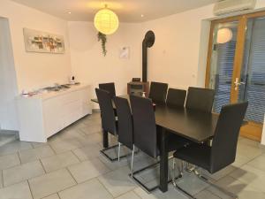 a dining room with a black table and black chairs at Gite de Circourt in Buxières-sous-les-Côtes