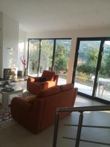 a living room with two couches and a large window at Villa Alfareed فيلا الفريد سراييفو in Sarajevo