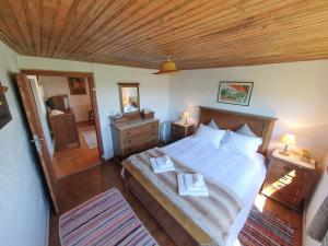 a bedroom with a large bed and a wooden ceiling at Casa das Lages in Viariz