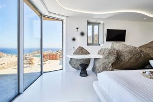 a bedroom with a bed and a view of the ocean at Teal Rock Mykonos in Ano Mera