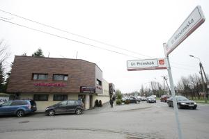 znak drogowy z samochodami zaparkowanymi przed budynkiem w obiekcie Villa & Spa w mieście Łomianki