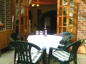 a white table with two chairs and a bottle of wine at Whitecliff View in Sandown