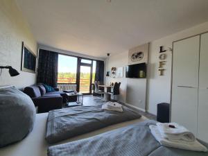 ein Schlafzimmer mit einem Bett und ein Wohnzimmer in der Unterkunft Harz Loft - Vier Jahreszeiten in Hahnenklee-Bockswiese