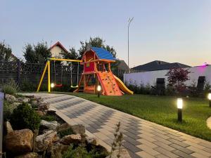 einen Spielplatz mit Rutsche im Hof in der Unterkunft SHIMresidence LUXURY in Rădăuţi