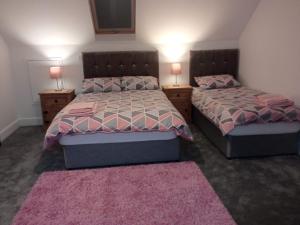 1 dormitorio con 2 camas y 2 mesitas de noche con lámparas en Greenway Guesthouse, en Mullingar