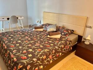 una camera da letto con un letto con copriletto floreale di Calle la Cala, 2 a Benidorm