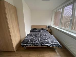 a bedroom with a bed with a black and white comforter at Apartmány Černý Tulipán 5 in Pilsen