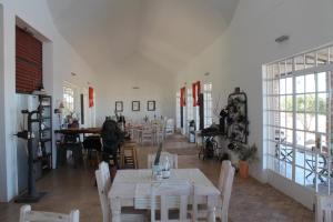 a dining room with tables and chairs and windows at Alte Kalkoefen Lodge in Simplon