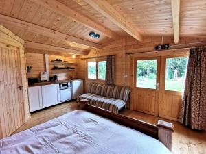 una camera con un letto e un divano in una cabina di The Oaks Luxury Lodges a Drumahoe