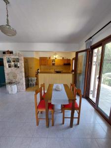 una sala da pranzo con tavolo e sedie e una cucina di Dimitrios a Porto Kagio