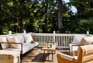 a porch with a white couch and two chairs at AWOL Kennebunkport in Kennebunkport