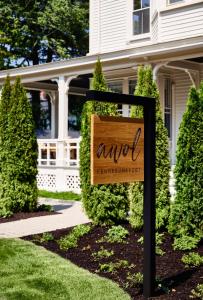 een bord in een tuin voor een huis bij AWOL Kennebunkport in Kennebunkport