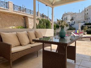 un divano e un tavolo con un vaso su un patio di Lamanna SUMMER HOUSE a Polignano a Mare