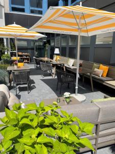 a patio with tables and chairs and umbrellas at SAXX Hotel "Am Theater Karree" in Hagen