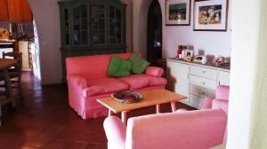 ポルト・チェルボにあるBeautiful Villa With Sea View to Porto Cervoのリビングルーム(ピンクのソファ、テーブル付)