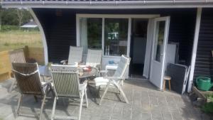 un grupo de sillas y una mesa en un patio en 6 Fyrrevej, Noerre Lyngby en Løkken