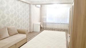 uma sala de estar com um sofá e uma janela em Center Apartment on Albisoara Street em Chisinau