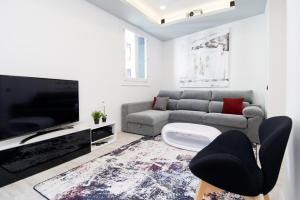 a living room with a couch and a flat screen tv at Condo San Bernardino by Kivoya in Madrid