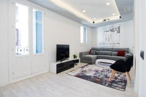 a living room with a couch and a tv at Condo San Bernardino by Kivoya in Madrid