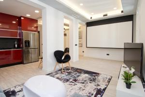 a living room with a black chair and a projection screen at Condo San Bernardino by Kivoya in Madrid