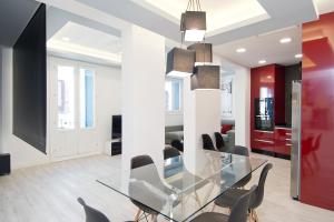 a dining room with a glass table and chairs at Condo San Bernardino by Kivoya in Madrid