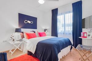 - une chambre dotée d'un grand lit avec des oreillers rouges et bleus dans l'établissement Apartamento La Marina, à Arona