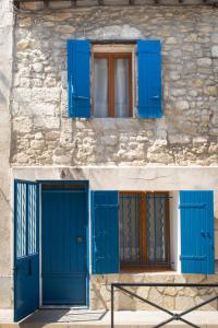 een gebouw met blauwe deuren en een raam bij La Maison bleue in Arles