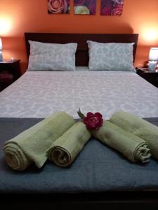 a bed with two towels and a flower on it at Nasos's Country House in Porto Rafti