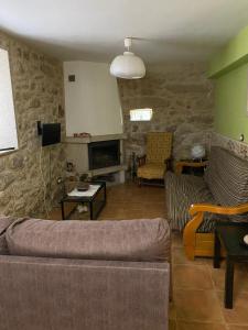 een woonkamer met een bank en een tv bij Casa El Hórreo in Laxe