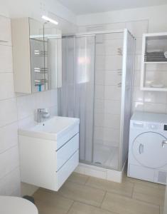 a white bathroom with a sink and a washing machine at Paradies Für Zwei in Frauenkirchen