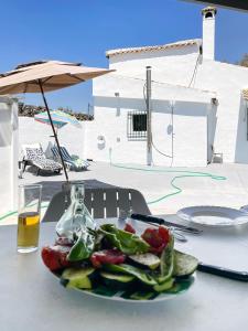 a plate of vegetables on a table with a drink at Cortijo La Viñolilla en zona rural (Montefrío) in Montefrío
