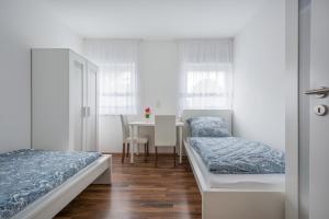 sypialnia z 2 łóżkami i stołem z jadalnią w obiekcie Merve Comfort Aparts4-Hannover w Hanowerze