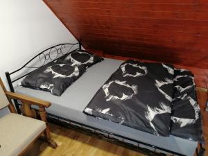 a bed with a black and white blanket on it at Domek pod Karpaczem in Mysłakowice