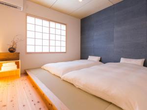 2 Betten in einem Schlafzimmer mit Fenster in der Unterkunft GOTEN TOMOE residence in Fujinomiya