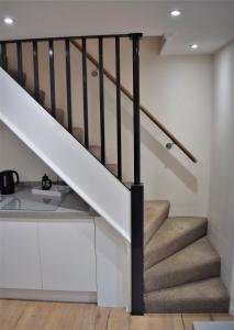 a staircase in a house with white walls and brown stairs at Osprey Cottage, Manton in Rutland in Manton