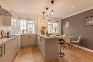 a kitchen with white cabinets and a table with chairs at Luxury Southampton house with garden and parking in Southampton