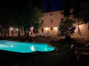 a swimming pool in front of a building at night at Il Castagnolo B&B in San Gimignano