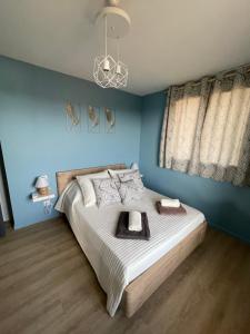 um quarto com uma cama grande e paredes azuis em L’alsace em Carcassonne