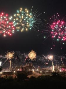 un montón de fuegos artificiales explotando en el cielo por la noche en L’alsace, en Carcassonne