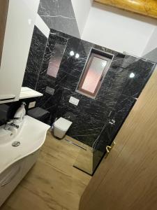 a bathroom with a sink and a toilet and a mirror at Guest House Bracaj in Çorovodë